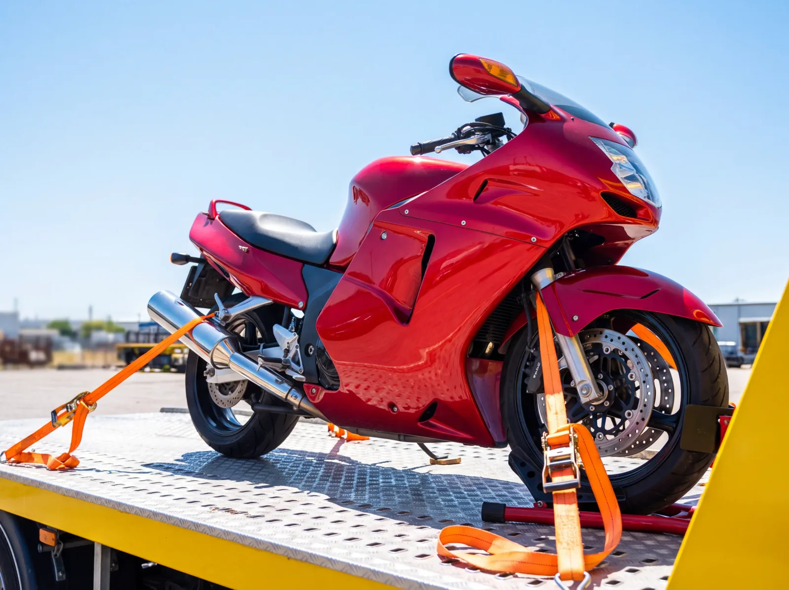 Motorradtransport Rotes Sportmotorrad mit Spanngurten auf der Ladefläche gesichert